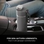 Graue Ninja Thirsti Trinkflasche (530 ml) im Getränkehalter eines Autos.
