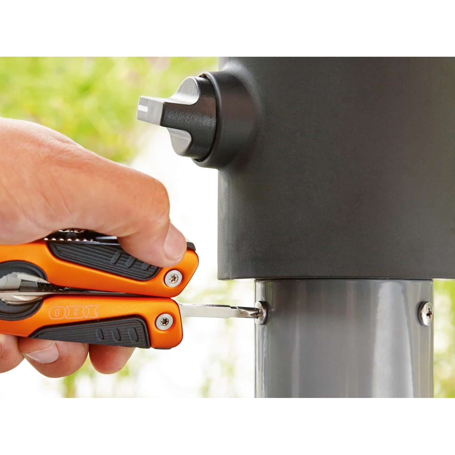 OBI Multitool 12-in-1 im Einsatz: Schraube wird mit Schraubendreher angezogen.