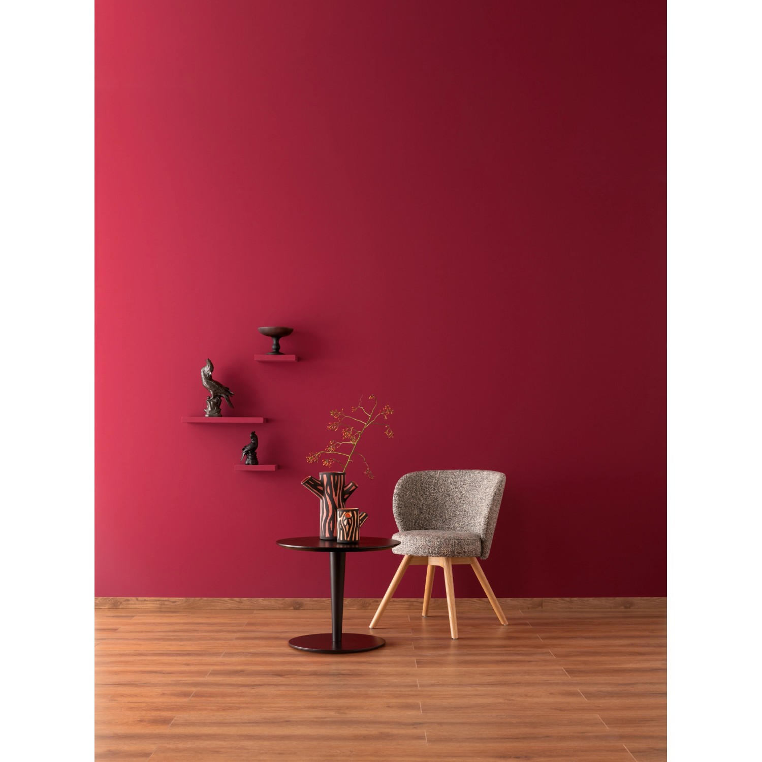 Schöner Wohnen Designfarbe Gefühlvolles Herzensrot, matte Wandfarbe im Wohnraum mit Möbeln.