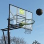 EXIT Galaxy Basketballkorb, grün/schwarz, zur Bodenmontage mit Ball vor blauem Himmel.