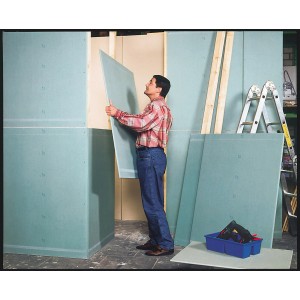 Mann montiert grüne Gipskarton Top 2000 Platte. Imprägniert und faserverstärkt.