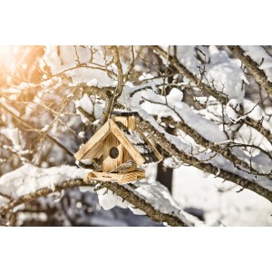 Vogelfuttersilo Villa aus Holz mit Vogel im Winter, Futterspender für Gartenvögel.