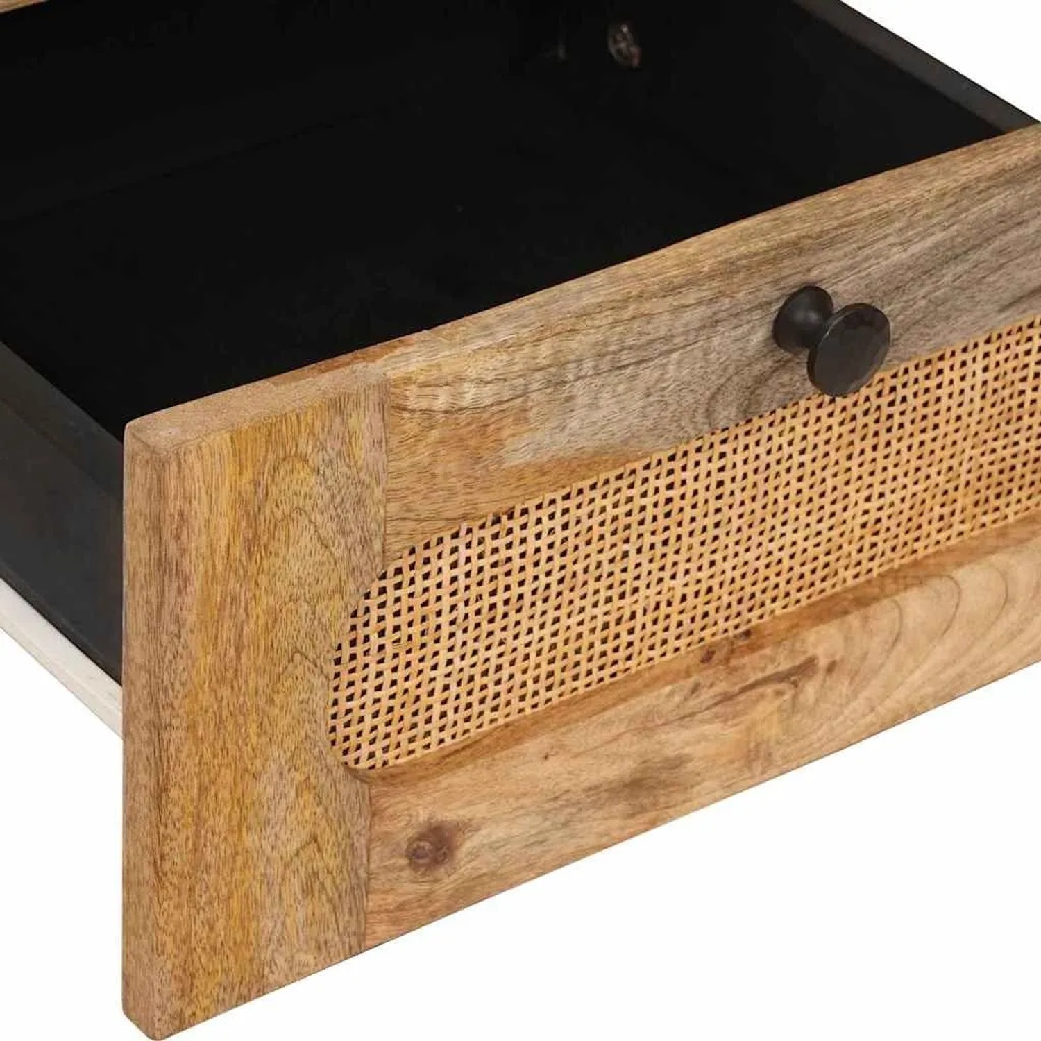 Offene Schublade eines Nachttisches aus massivem Mangoholz mit Rattan-Geflecht und dunklem Innenraum.