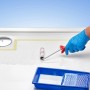 Auftragen des transparenten Antirutsch-Anstrichs im Bad mit Farbroller. Set für Badewannen und Duschen.