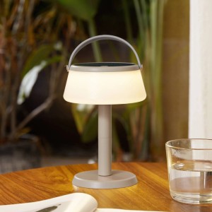 Moderne Lindby LED Mikkel Solar-Tischleuchte in Creme mit grauem Griff, dimmbar, spritzwassergeschützt, auf Holztisch.