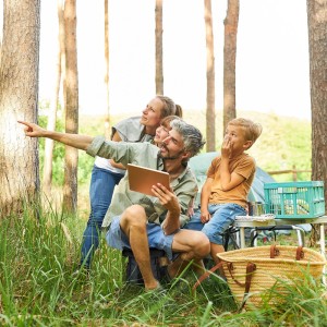 Familie beim Camping, sitzend auf Relaxdays Teleskophocker 2er Set, schwarz.