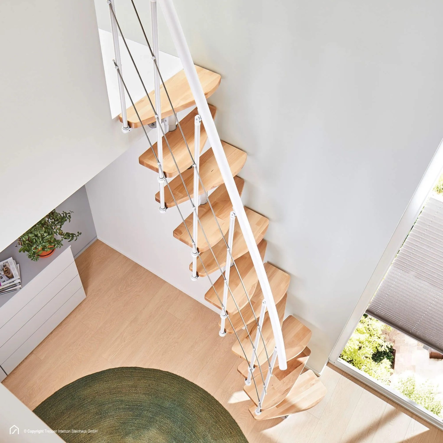 Moderne Intercon Raumspartreppe Alpha mit hellen Buchenholzstufen und weißem Metallgeländer in hellem Raum.
