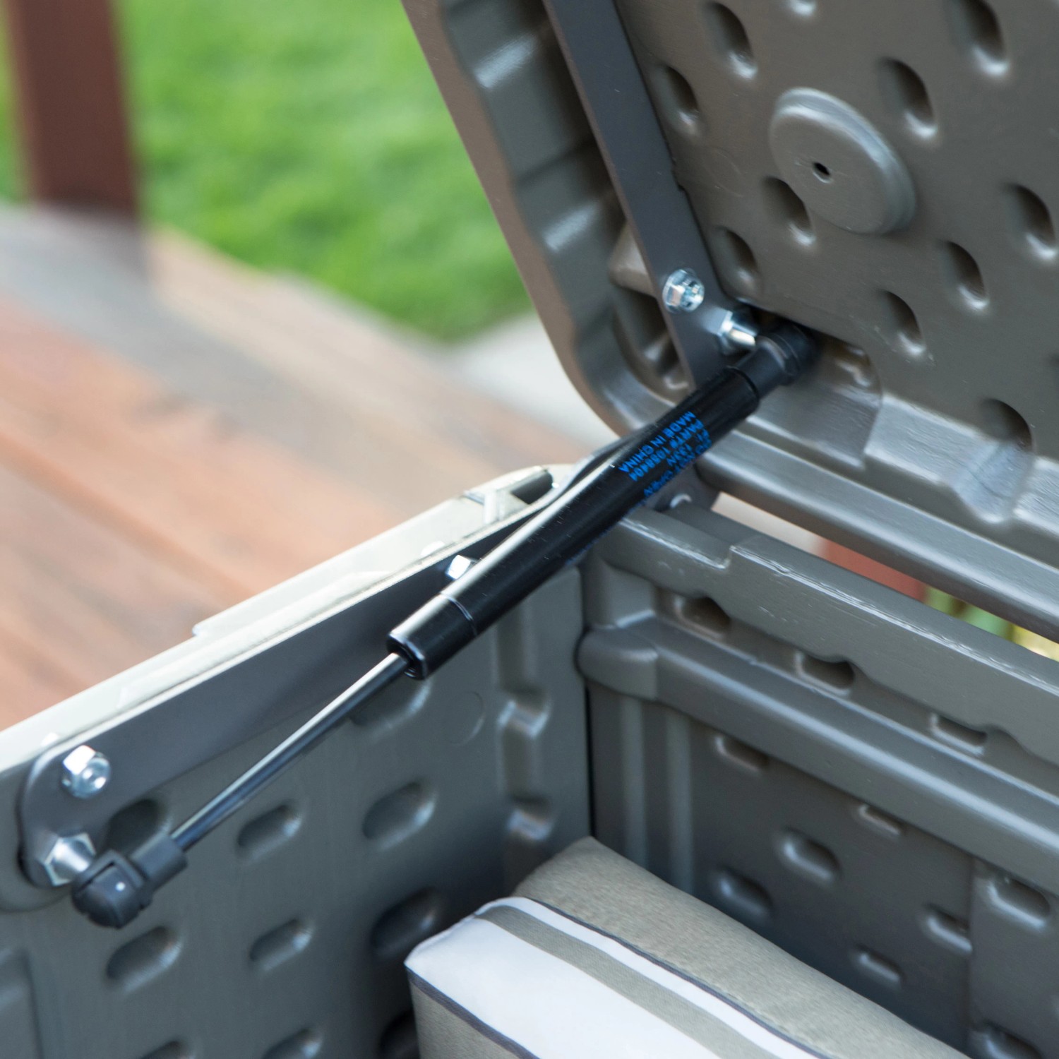 Detailaufnahme: Gasdruckfeder der Lifetime Gartenbox, dunkelbraune Universalbox mit geöffnetem Deckel.