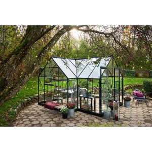 Halls Gewächshaus Icon Gardenhouse 8, 13 m², grün, mit Pflanzen und Gartenmöbeln im Außenbereich.