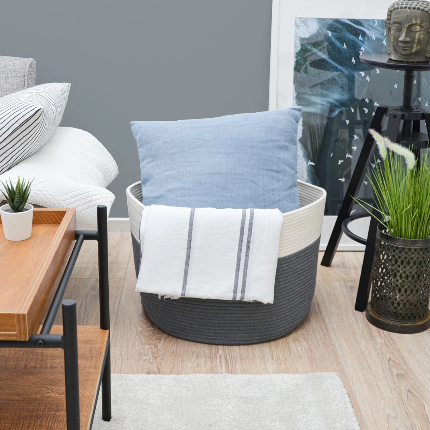 XXL Aufbewahrungskorb (Ø50cm) von DuneDesign, grau-weiß, gefüllt mit Kissen und Decke.