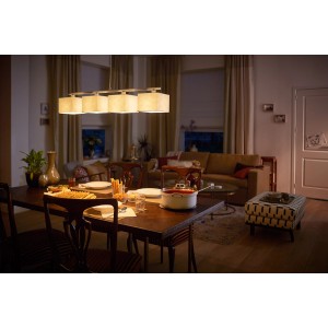 Philips LED-Leuchtmittel E14 Kerze, 3er-Set, in Wohnraum-Szene mit Esstisch und Sofa.