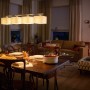 Philips LED-Leuchtmittel E14 Kerze, 3er-Set, in Wohnraum-Szene mit Esstisch und Sofa.