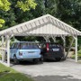 Weißer Skan Holz Carport Schwarzwald mit Dachlattung für zwei PKW im Garten.