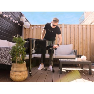 Schwarzer Axi Kühlwagen Retro 76 l mit Mann im Garten, ideal für Partys und zum Kühlen von Getränken.