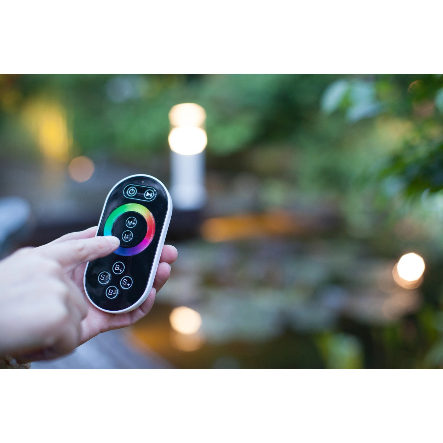 Heissner RGB-Controller für Teichbeleuchtung mit Farbrad-Fernbedienung in der Hand.