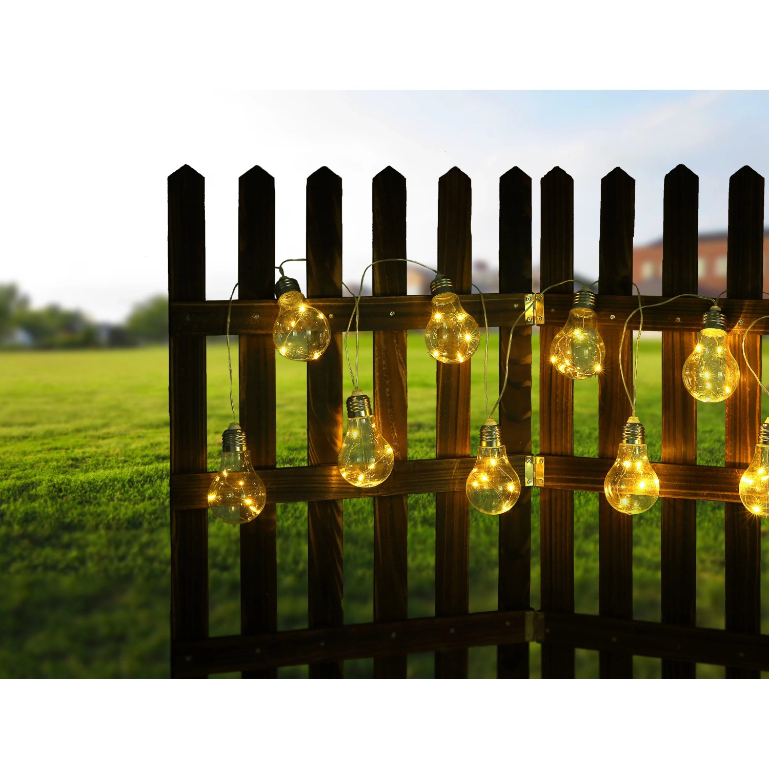 Globo LED-Solarlichterkette mit 10 warmweißen Birnen an einem Holzzaun im Garten.