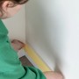 Anwendung von gelbem Wallpro Abdeckband 25mm x 50m zum Abkleben einer Wandleiste.