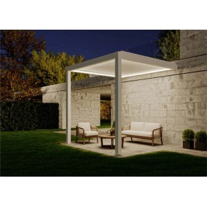 Weiße, wandmontierte Huun Pergola Mezzo 300x300 cm mit LED-Beleuchtung und Sitzgruppe im Garten.