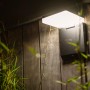 Schwarze, eckige Lutec Solar-LED-Außenleuchte Moze mit Bewegungsmelder an Holzwand.