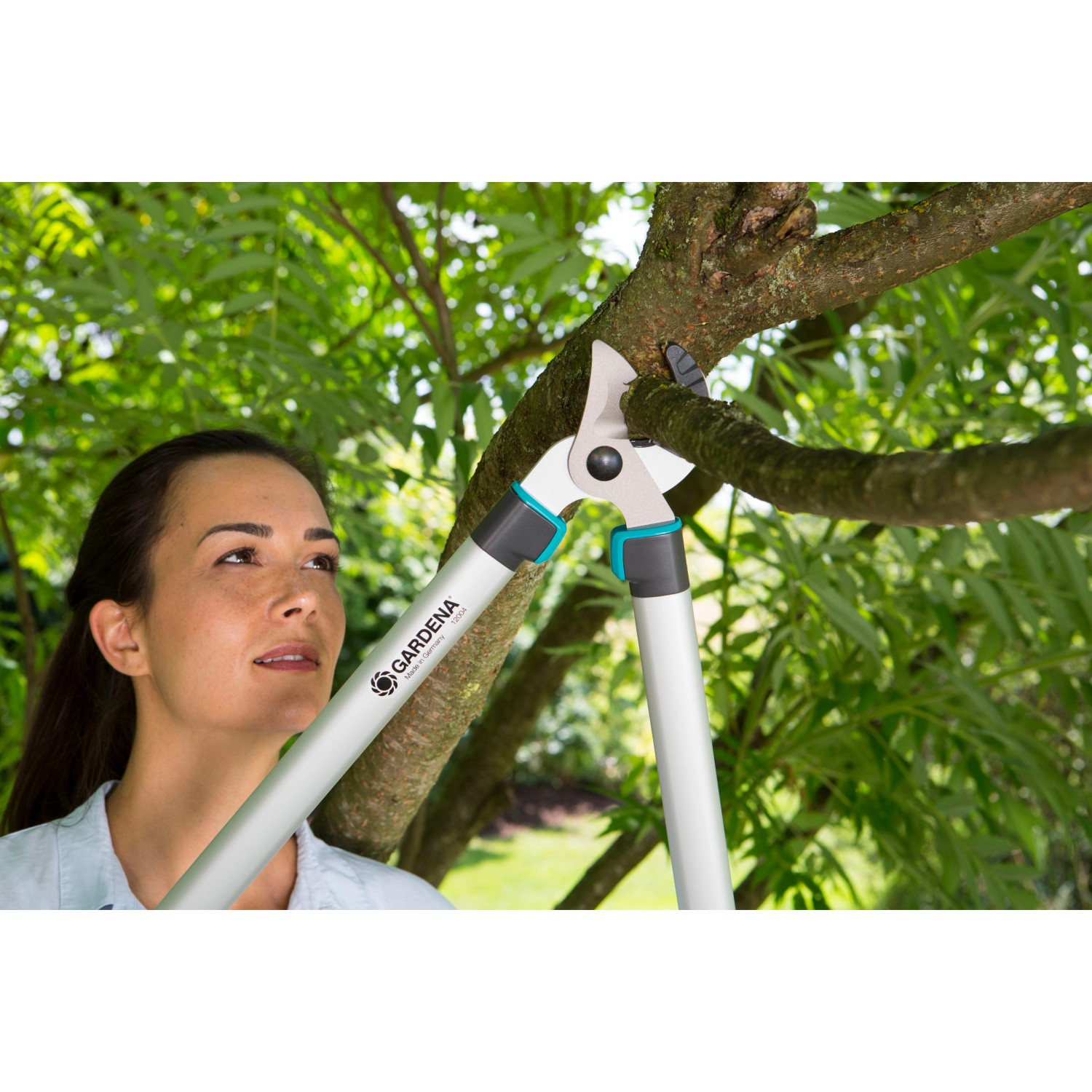Frau schneidet Ast mit Gardena EasyCut 680 A Amboss-Astschere im Garten.