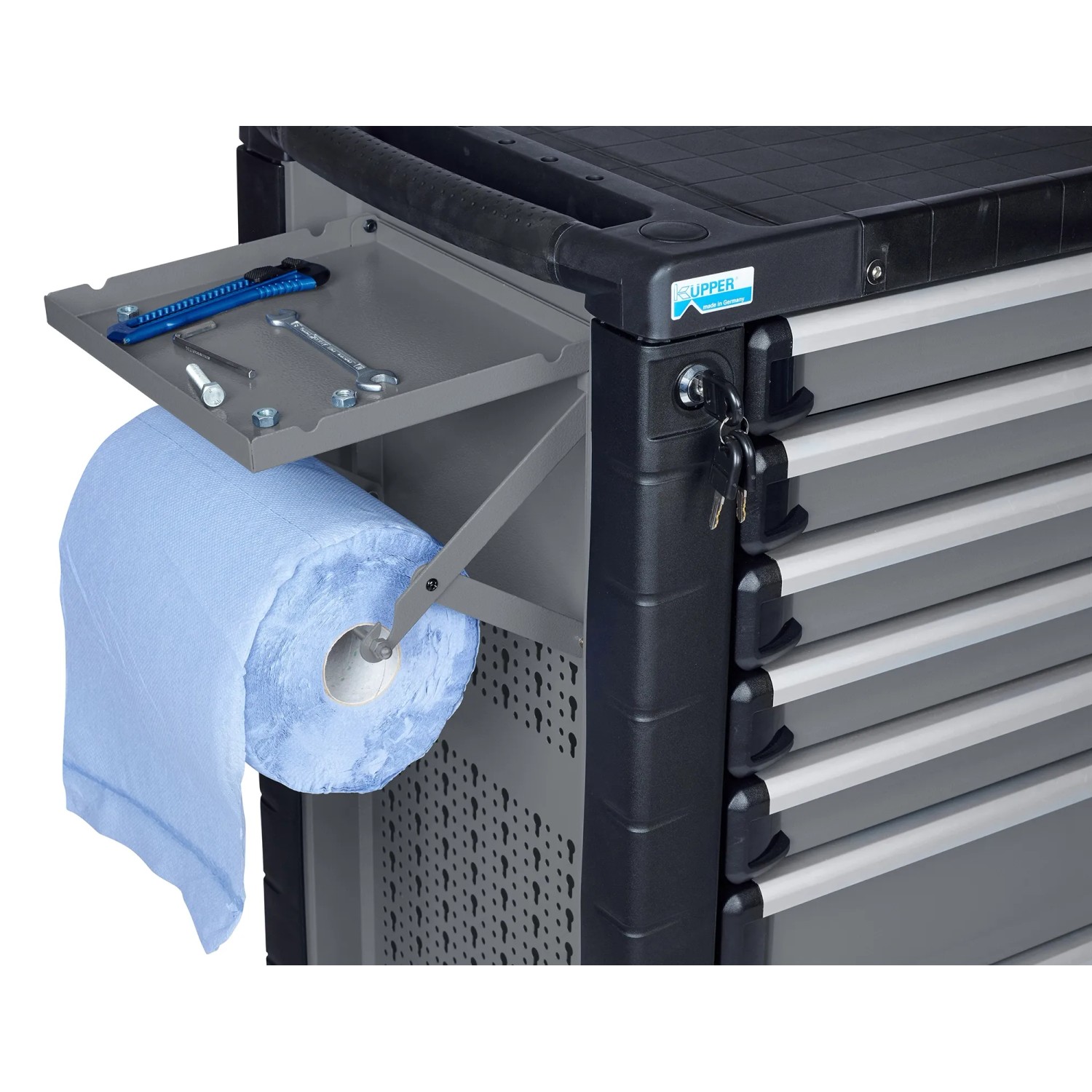 Küpper Papierrollenhalter, hellgrau, an Werkbank montiert, mit Papierrolle, Ablagefach und Werkzeugen.