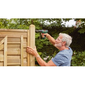Mann nutzt Bosch 12 V Akku-Bohrschrauber EasyDrill 1200 für Montage am Holzzaun im Garten.