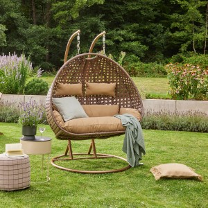 Home Deluxe Hängesessel Twin aus Polyrattan in Braun mit beigen Kissen im Garten.