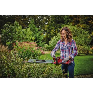 Frau schneidet Hecke mit Einhell Akku-Heckenschere GE-CH 36/61 Li-Solo.