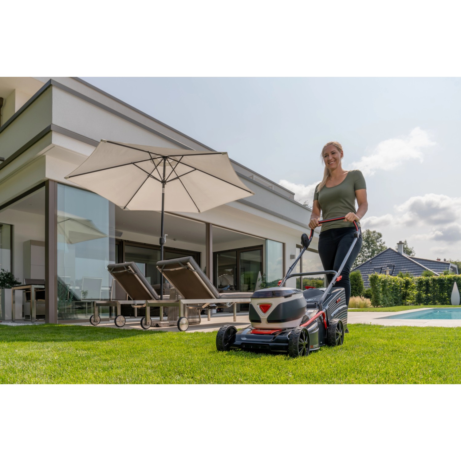 Frau mäht Rasen mit Al-Ko Akku-Rasenmäher 42.2 Li Comfort im Garten.