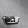Erismann Vliestapete Swing Anthrazit mit Wellenmuster an Wand hinter Stuhl.