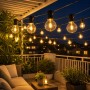 Salcar Solar G40 LED Lichterkette, warmweiß, beleuchtet eine Terrasse bei Nacht. Dekorative Außenbeleuchtung.