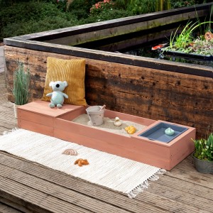 MUDDY BUDDY Sandkasten Space Saver in Puderrosa mit Spielzeug und Wasserbecken.