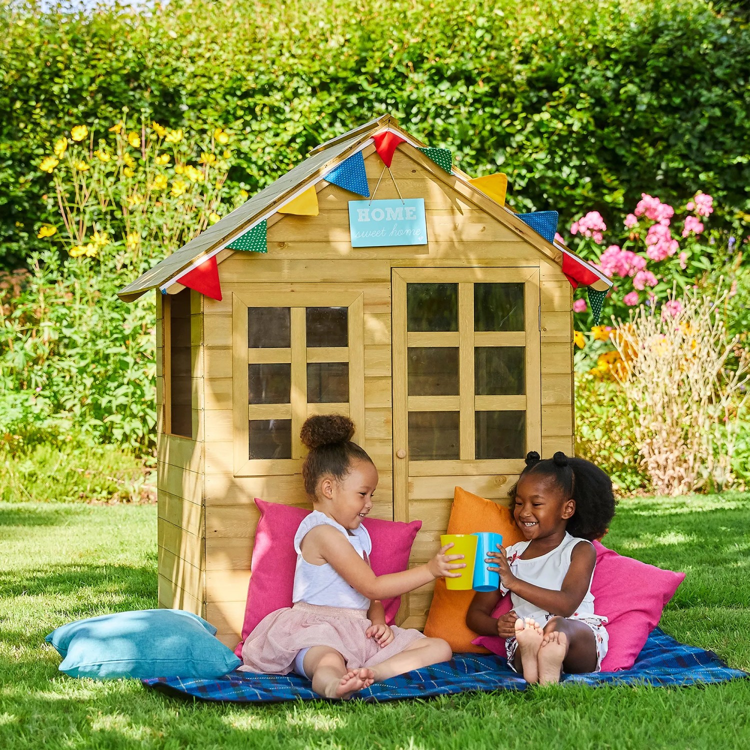 Zwerkules Spielhaus Holla aus Holz mit zwei spielenden Kindern im Garten.