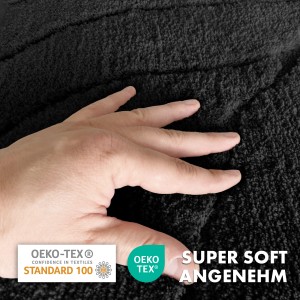 Detailaufnahme: Schwarze Karat Badematte Maris mit Hand, weicher Flor und Blattstruktur.