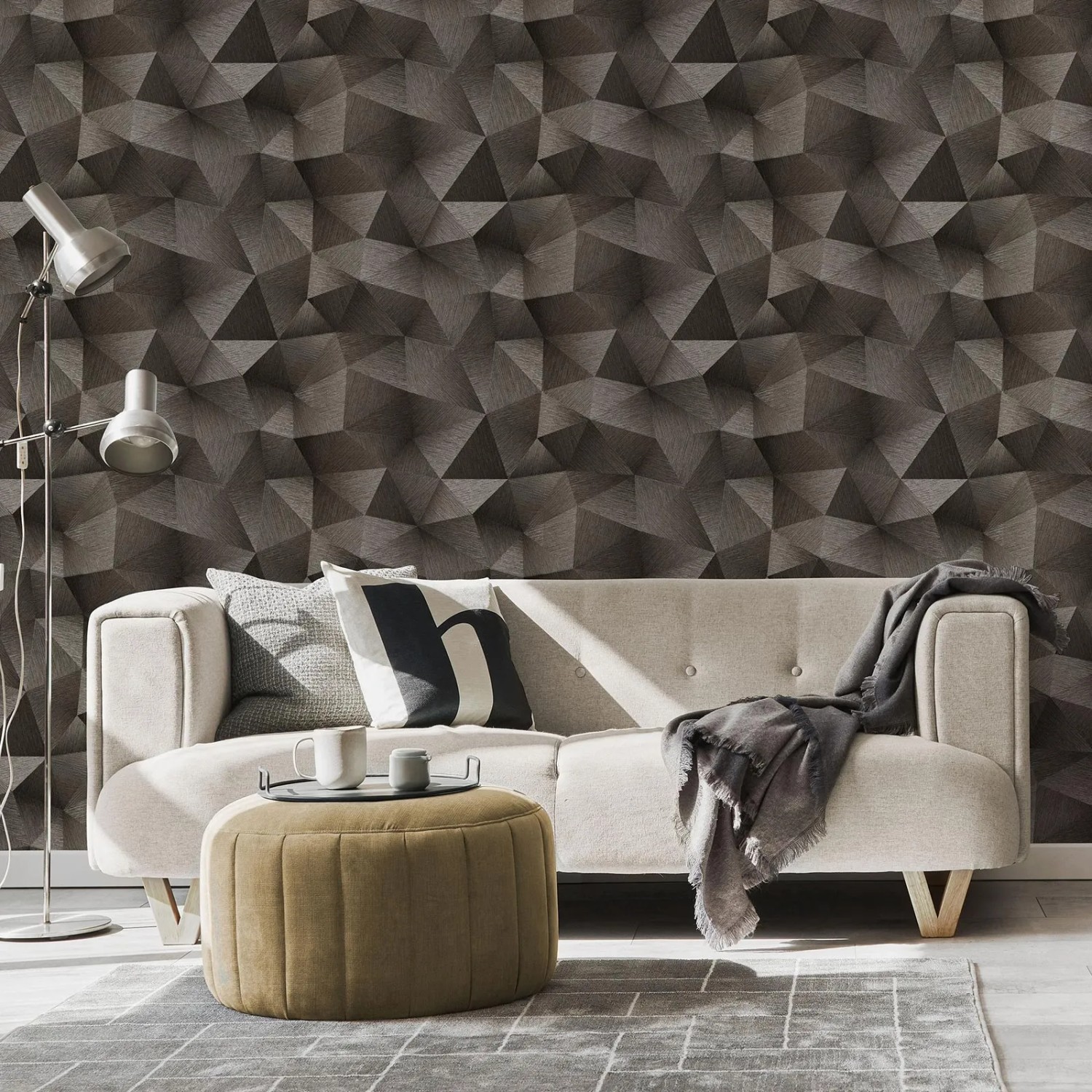 Wohnzimmer mit schwarzer Vliestapete mit grafischem Dreieck Muster und Metallic Effekt.