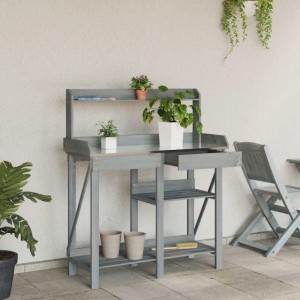 Grauer Pflanztisch aus Massivholz mit Ablagen und Schublade, bepflanzt auf einer Terrasse. Praktisches Gartenhilfsmittel.