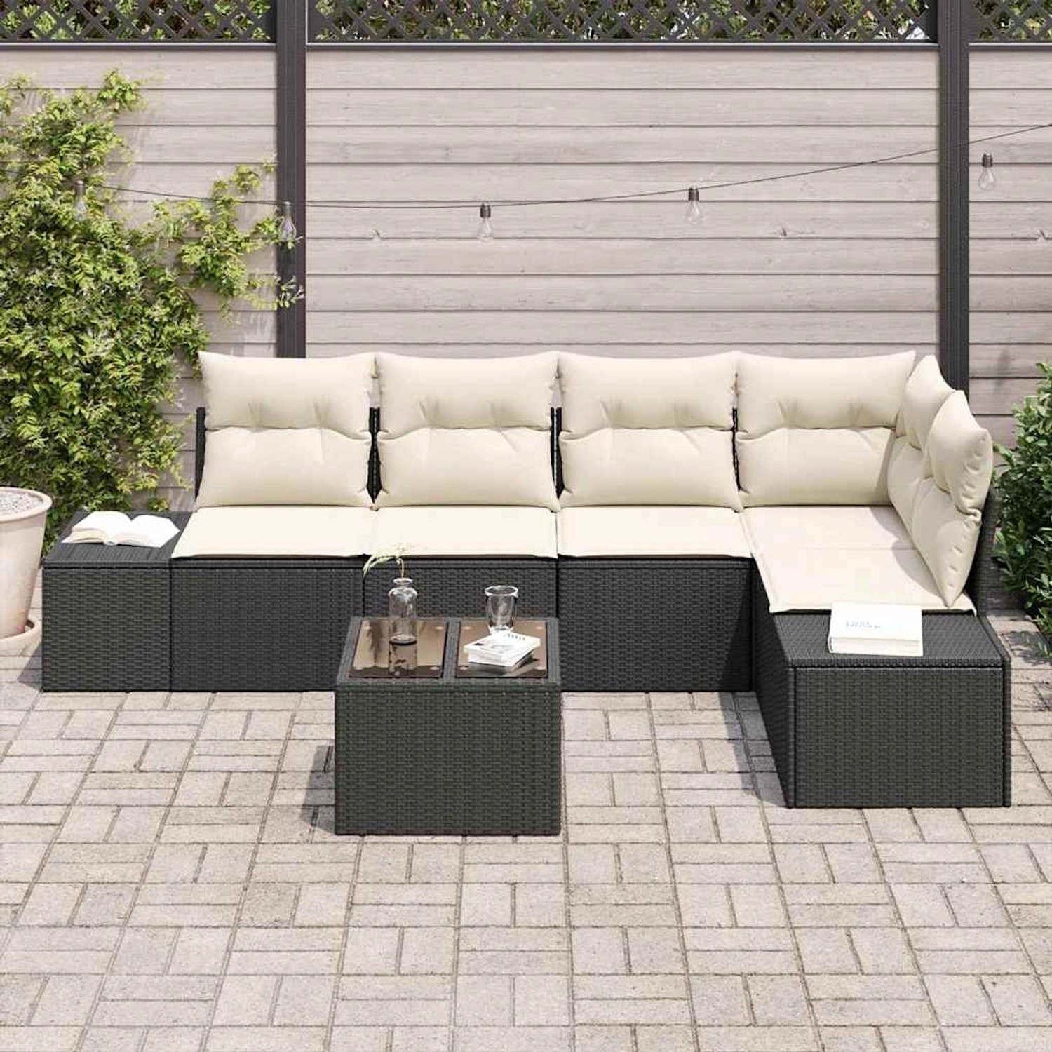 Schwarzes 6-teiliges Garten-Sofa-Set aus Poly Rattan mit Tisch und beigen Kissen.