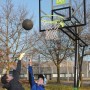EXIT Galaxy Basketballkorb, grün/schwarz, mit spielenden Kindern im Garten.
