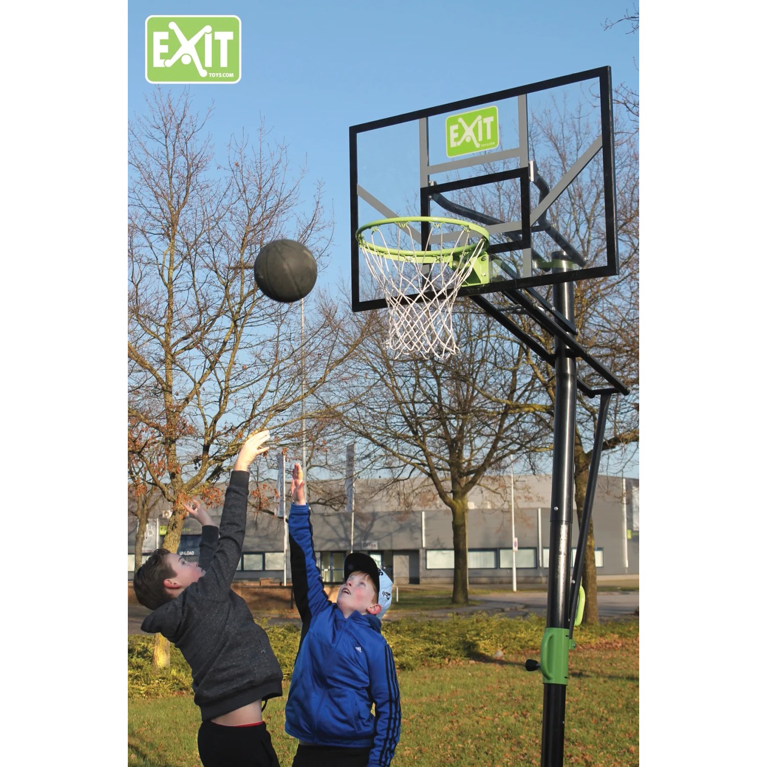 EXIT Galaxy Basketballkorb, grün/schwarz, mit spielenden Kindern im Garten.