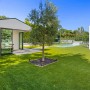 Satte, grüne Primaflor Kunstrasenfläche Cyprus im Garten mit Pool und Baum. Pflegeleichter Rasenteppich.