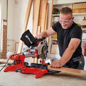 Einhell Zug-Kapp-Gehrungssäge TC-SM 2131/1 Dual im Einsatz beim Holzzuschnitt mit Schutzbrille.