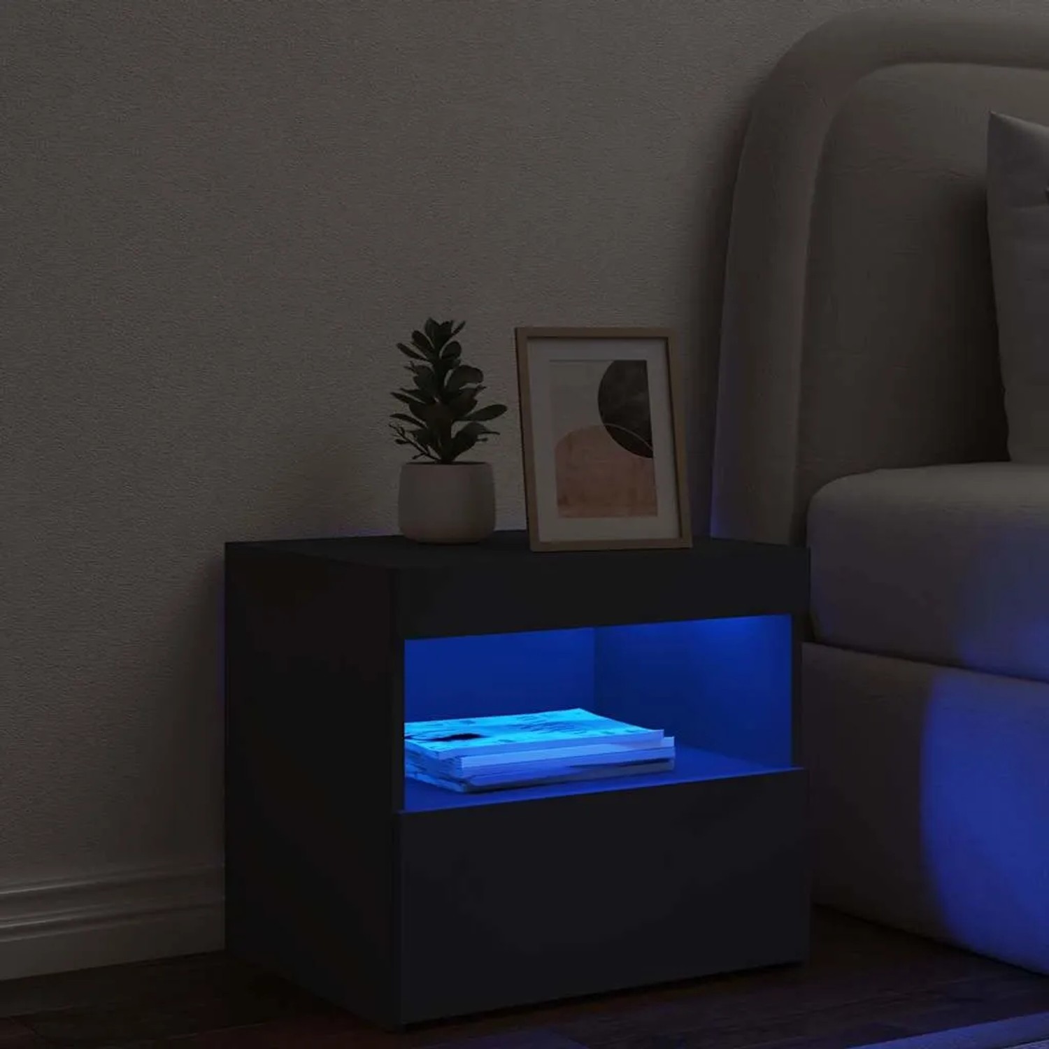 Schwarzer Nachttisch mit LED-Beleuchtung, 50x40x45 cm, neben einem Bett. Dekoration auf der Oberseite.