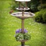 Westfalia Solar Vogelbad 4-in-1 Bronze mit zwei Vögeln im Garten.
