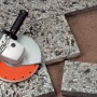 Diamant-Trennscheibe Turbo 115 mm im Einsatz mit Winkelschleifer zum Schneiden von Steinplatten.