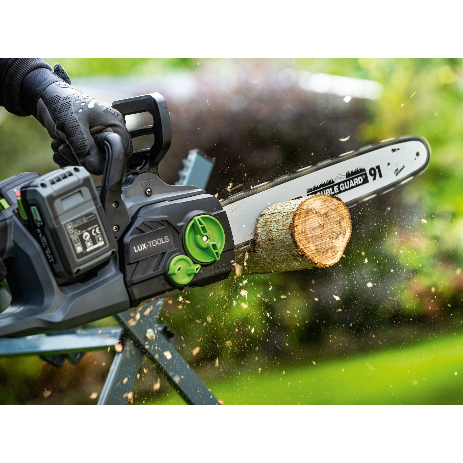 LUX-TOOLS Akku-Kettensäge A-KS-2x20/405 beim Sägen eines Holzstamms im Garten.