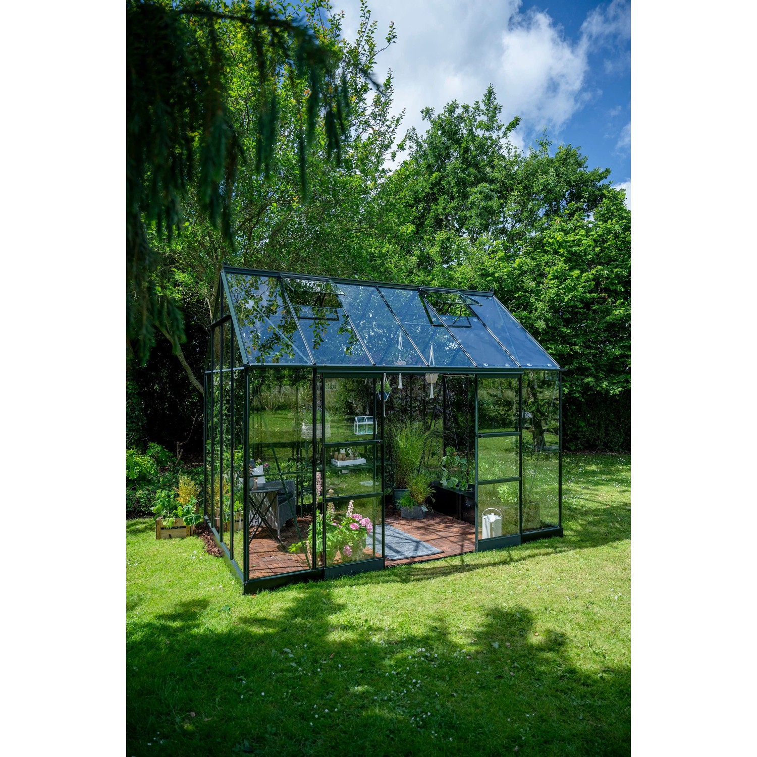 Helles, grünes Halls Gewächshaus Icon Planthouse 8 mit 9,7 m² im Garten.