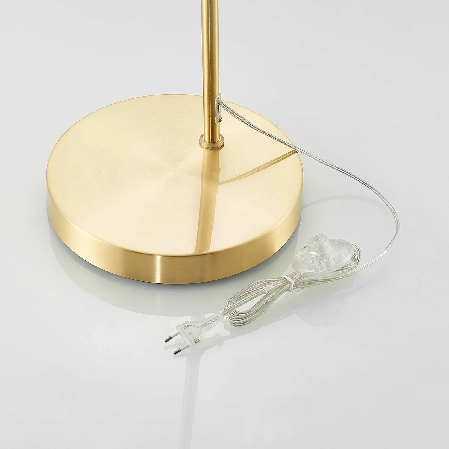 Detailaufnahme: Goldene Lindby Bogenleuchte Lennart mit Kabel und Stecker.