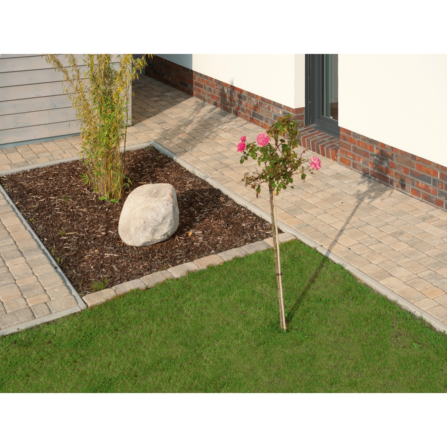 Verlegtes Diephaus Semito Mehrformat Pflaster Muschelkalk, 6 cm, im Garten mit Baum und Stein.