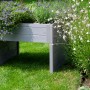 Graue Dobar Mährobotergarage mit Pflanzkasten, bepflanzt mit Blumen, im Garten.
