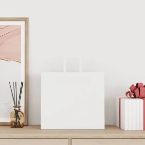 Weiße Papiertragetasche mit Henkeln auf Holzfläche, ideal als Geschenktüte oder Einkaufstasche.